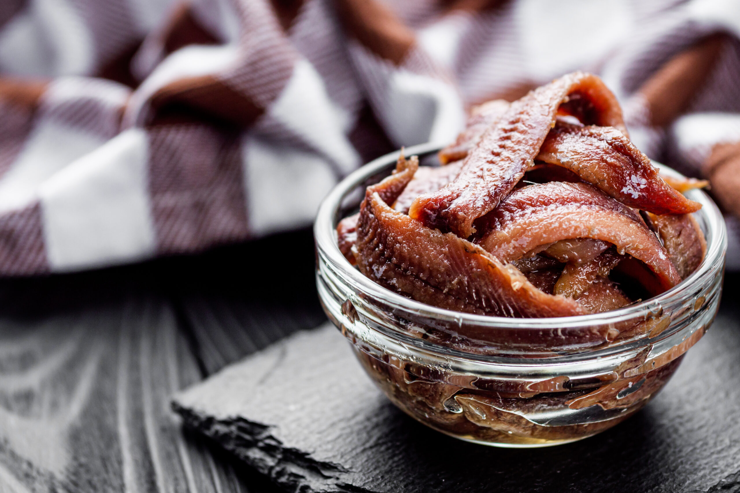 canned anchovy fillet on a black wooden rustic background